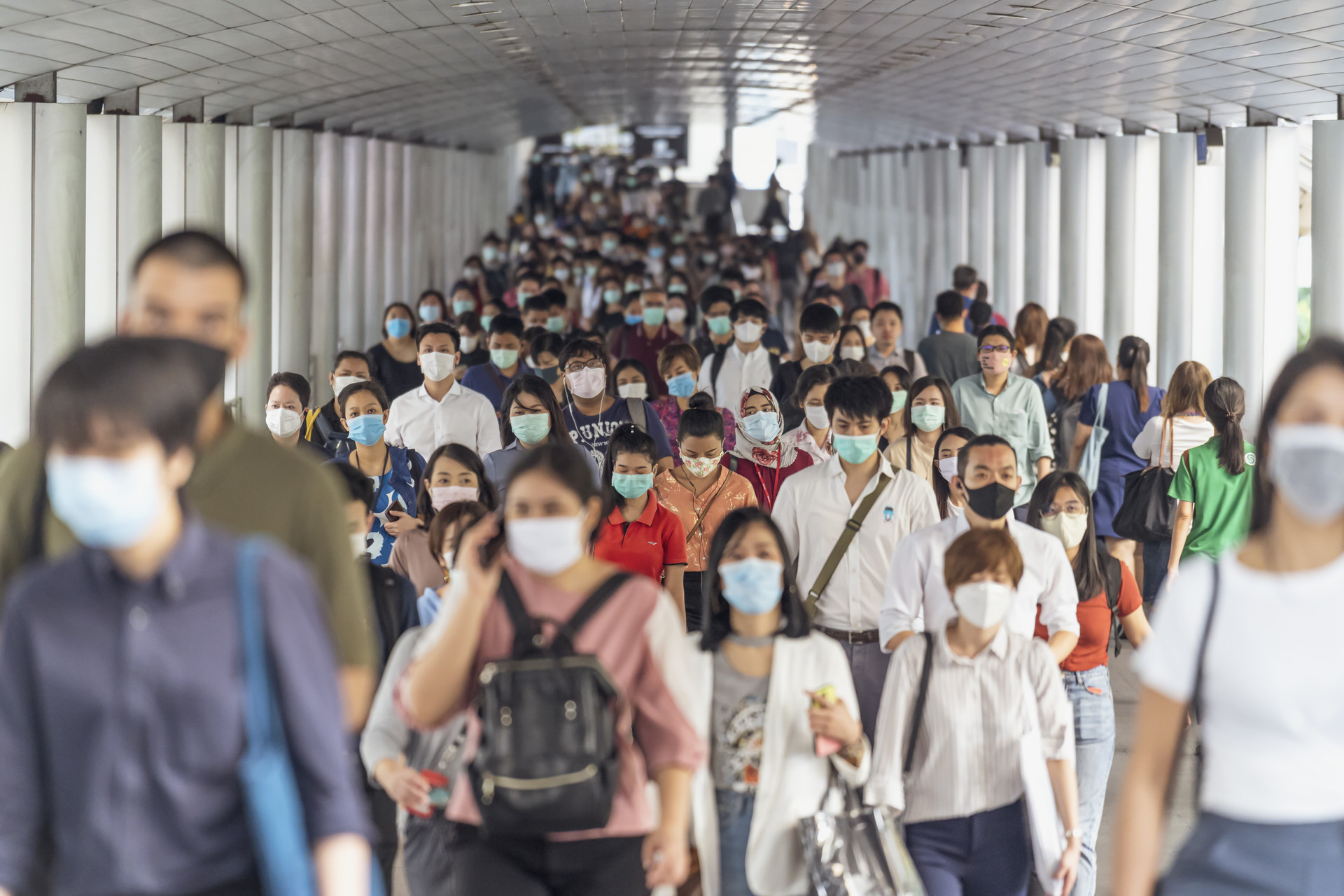 Crowd of unrecognizable business people wearing surgical mask for prevent coronavirus Outbreak in rush hour working day on March 18, 2020 at Bangkok transportation