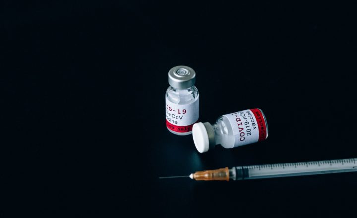 A syringe and two covid-19 vaccine bottles