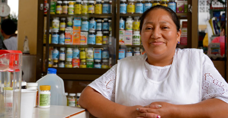 Ecuadorian woman from indian heritage posing in front of the camera in her market stall selling drugs at the public market.